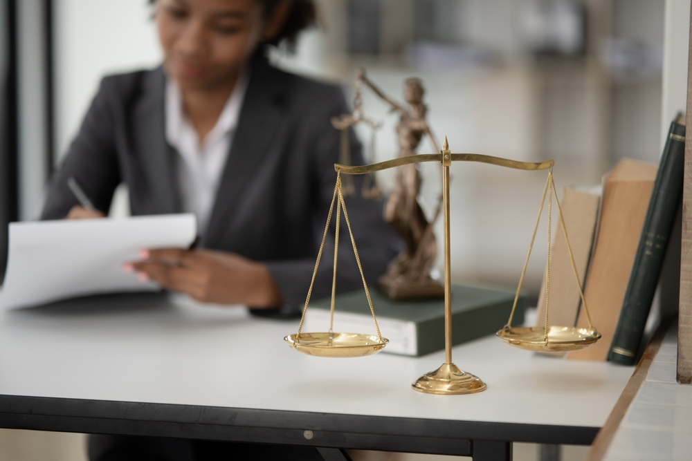 Golden Balancing Scales with a business women blurred in the back ground. Should you get a personal loan to improve credit score | Swoosh Finance
