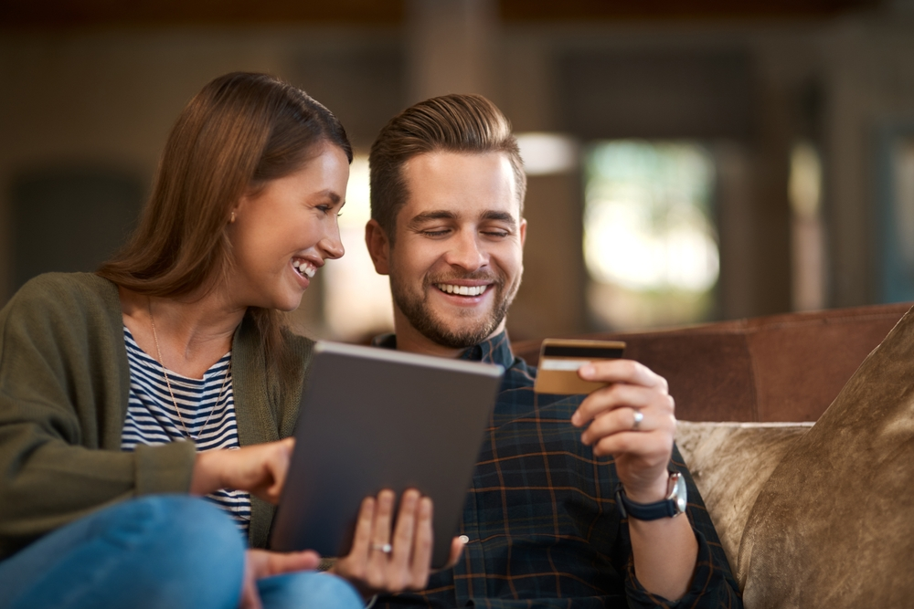 Happy couple researching different options for a loan | Swoosh Finance