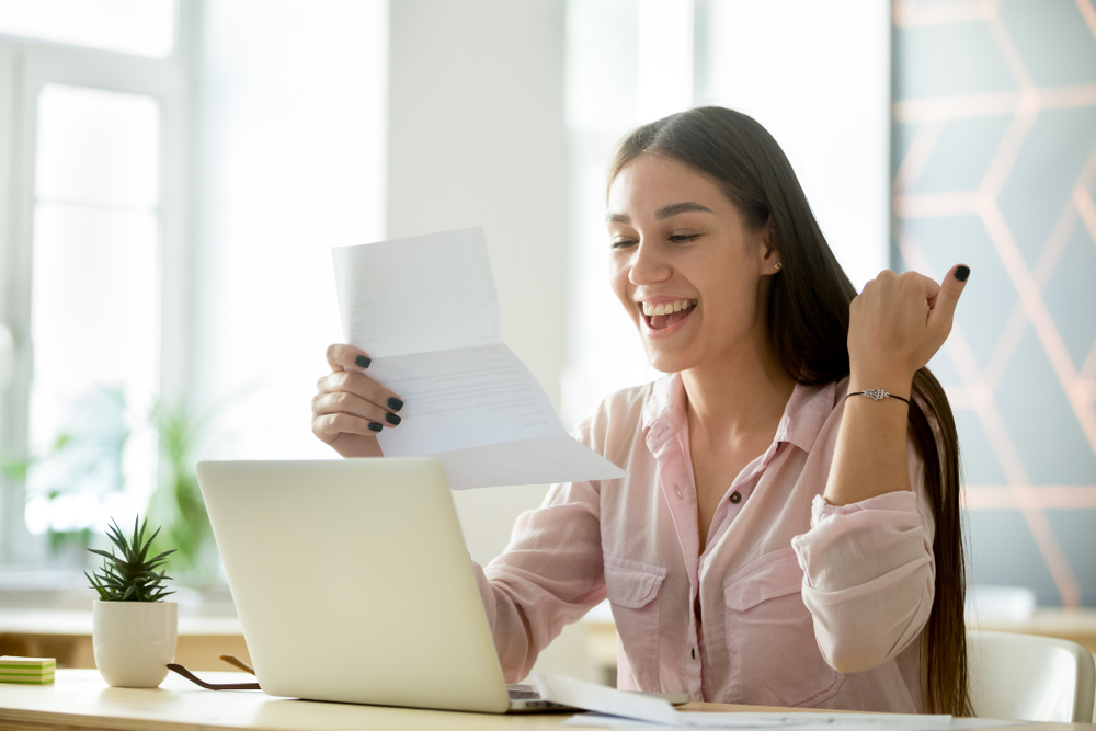 A girl celebrating because she was just approved for a loan. Should you get a personal loan to improve credit score | Swoosh Finance