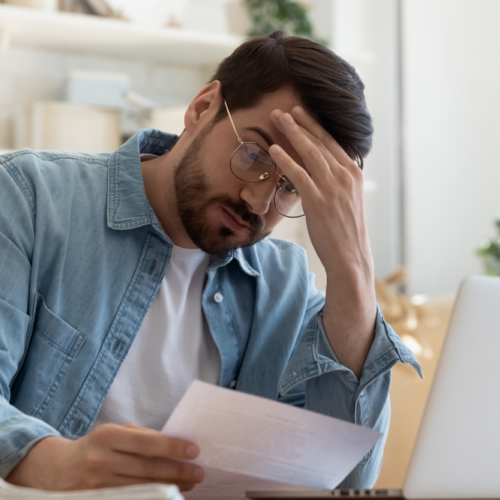 Worried man looking at his bills | Swoosh Finanace