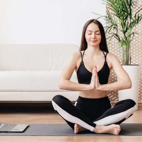 Woman doing yoga in her living room | Swoosh Finance