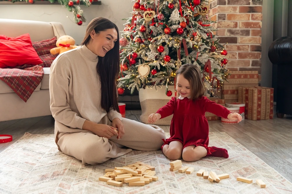 Mum and Daughter playing blocks on Christmas morning | Swoosh Finance