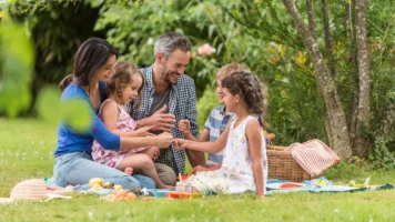 Family enjoing an outdoor picnic | Swoosh Finance