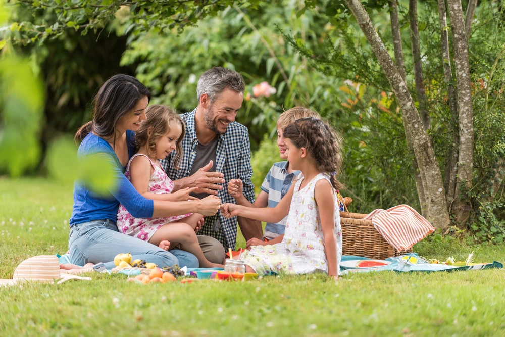 Family enjoing an outdoor picnic | Swoosh Finance