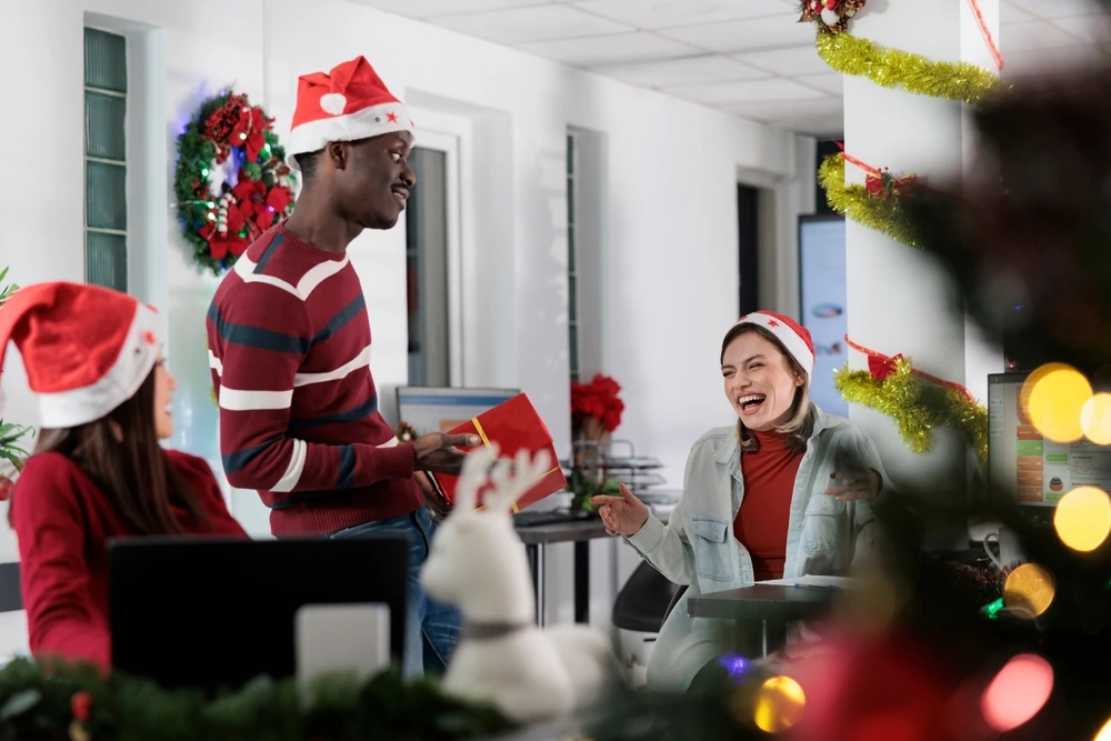 Co - workers handing out secret santa presents | Swoosh Finance