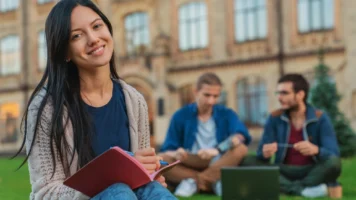 Uni student working on the grass | Swoosh Finance