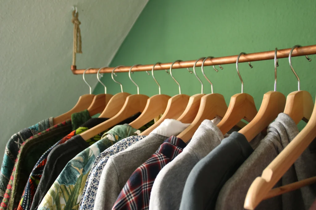 Clothes rack with shirts hung on hangers and neatly spaced apart